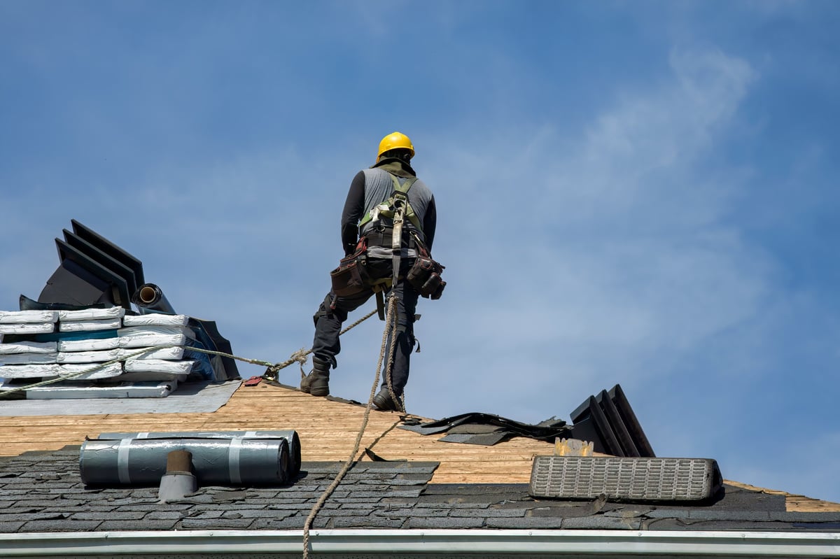Roofer fastening asphalt shingles with a pneumatic nail gun in Middletown PA