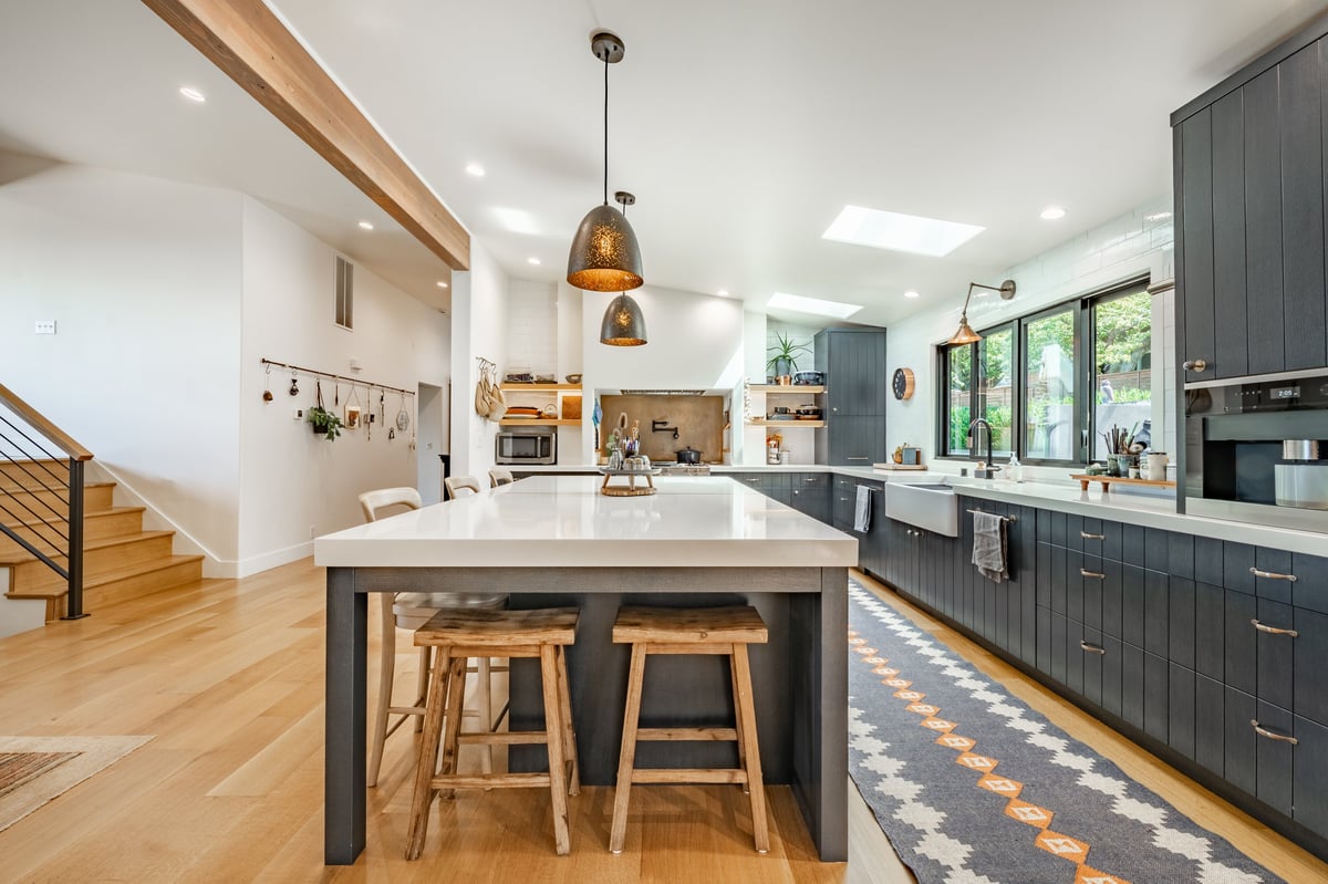 Finished kitchen remodel with dark cabinetry and island seating